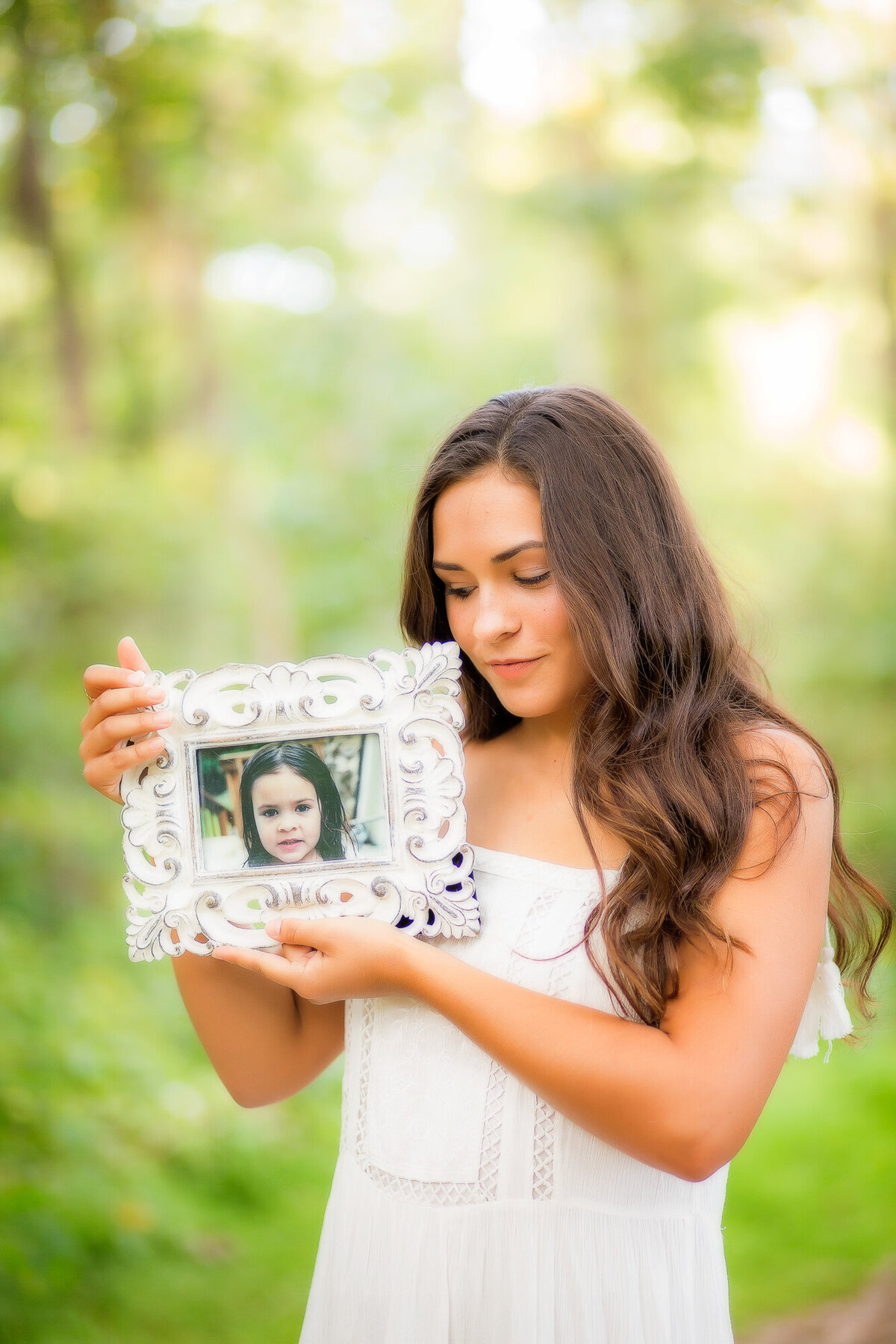 Color image of girl in white dress holding an image of herself