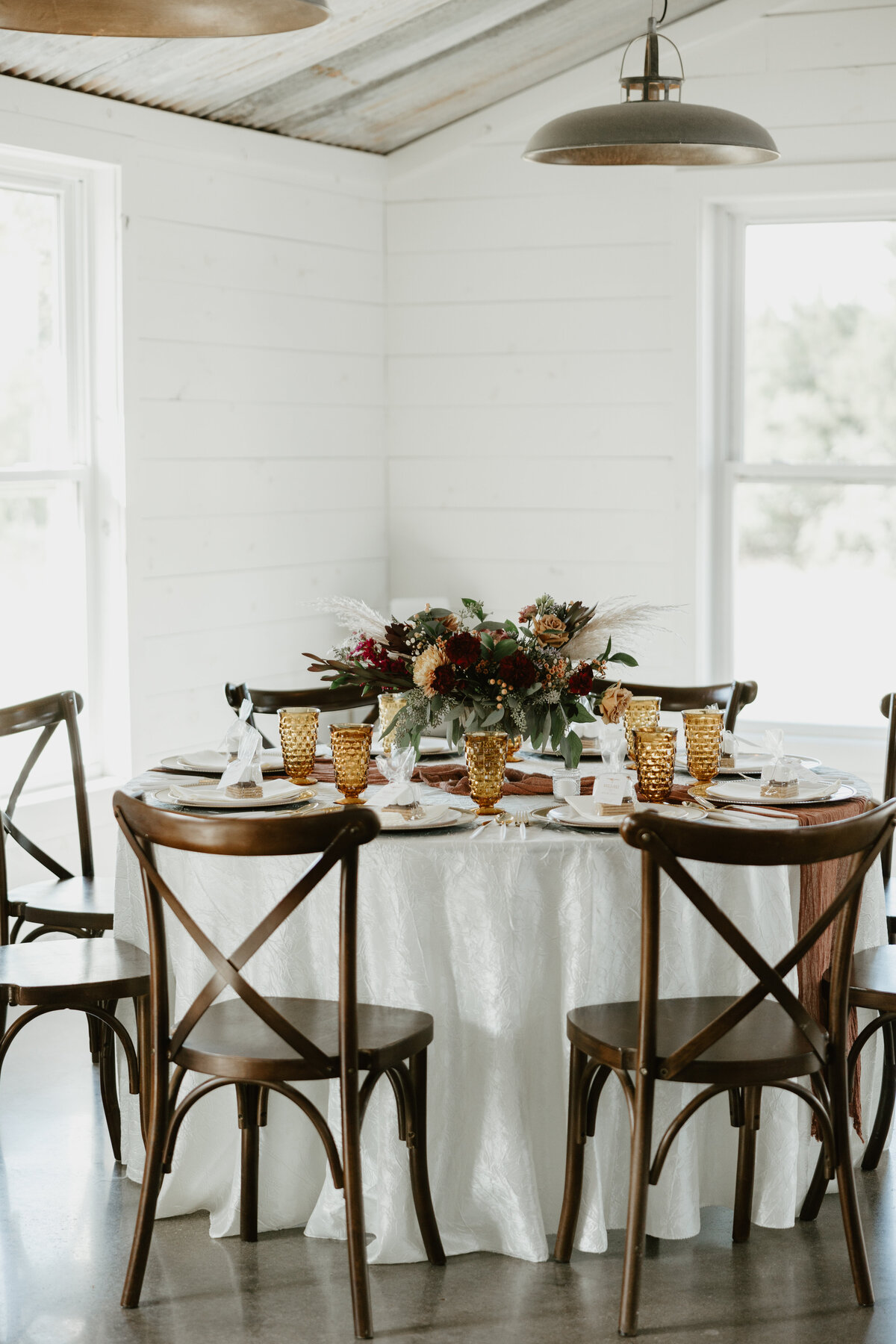 boho table setting with amber glasses and a boho inspired floral centerpiece