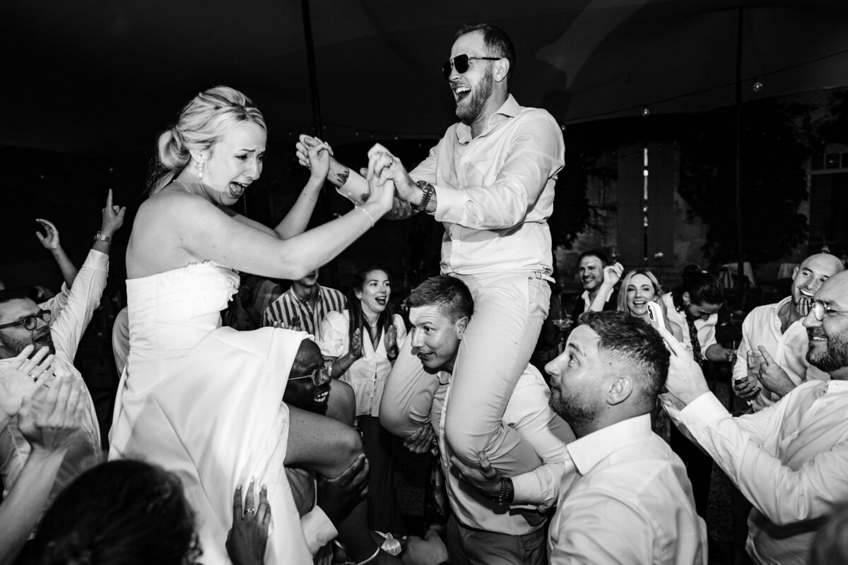 Bride and Groom on people's shoulders during the dancing.