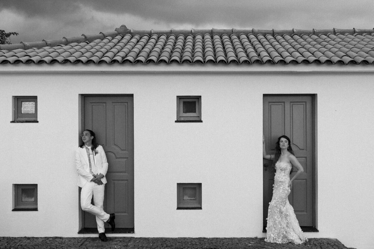 Bride and Groom standing in an editorial pose against the beauty in Vila Franca do Campo of the Azores islands in Portugal, photographed by Andrea-Marie Photography