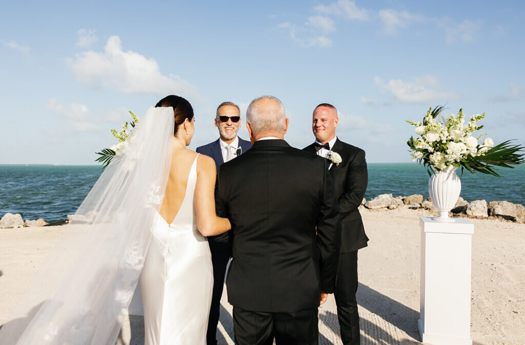 A touching moment as the bride’s father stands with her before handing her over to the groom at their oceanfront wedding ceremony in the Florida Keys. Captured by Claudia Amalia Photography, a Florida Keys wedding photographer specializing in destination wedding photography.