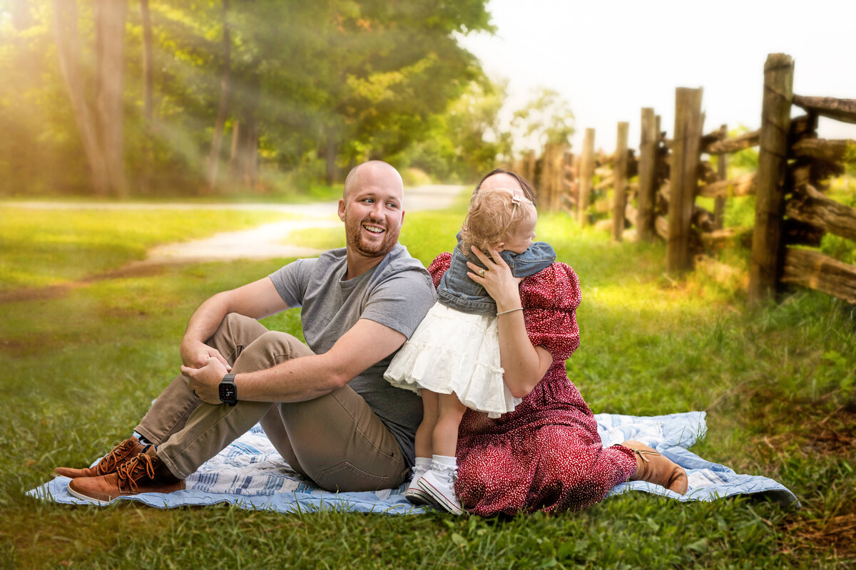 Candid outdoor family portrait at Bronte Provincial Park in Oakville, Ontario, featuring joyful toddler interaction and warm natural light.