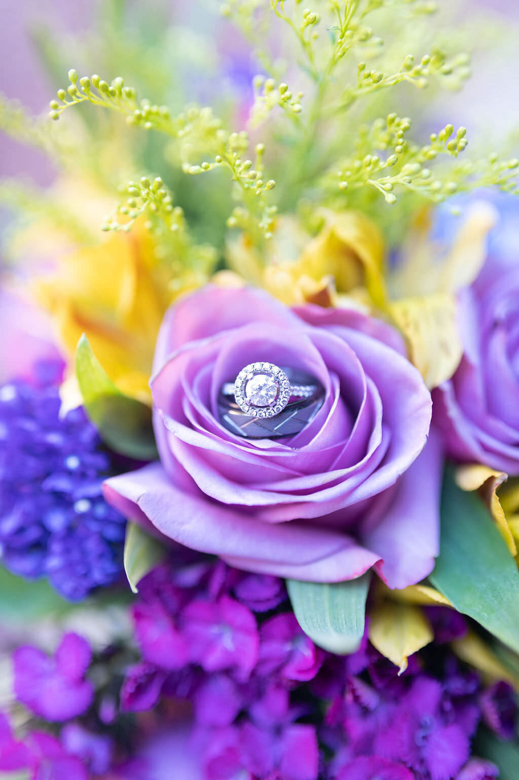 Wedding rings laid inside of a purple flower.
