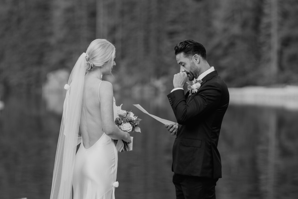 Black and white photo of emotional groom during vow exchange
