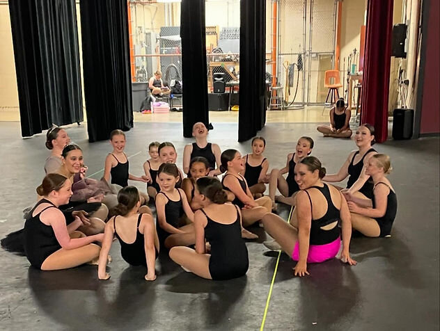 group of dancers stretching at stage rehearsal
