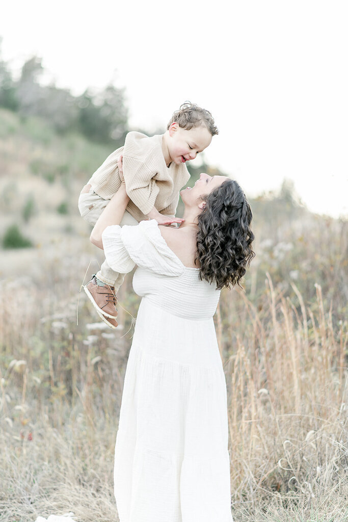 A mother holds her son in the air