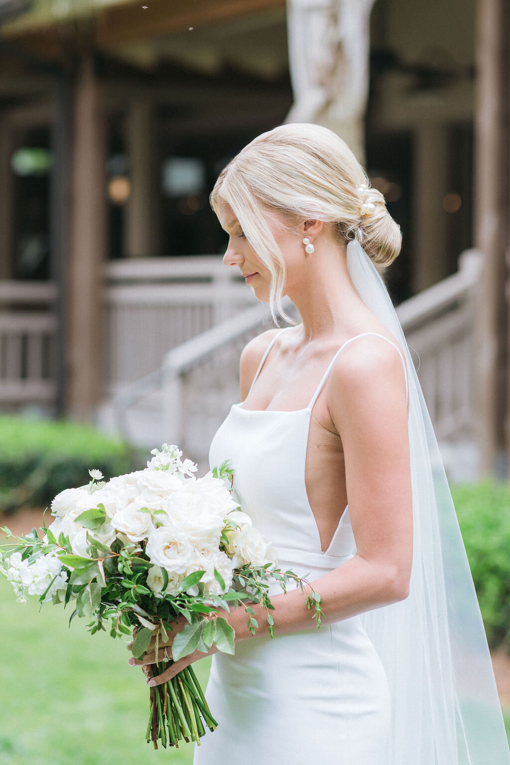 A stunning bride in a sleek white gown holding a bouquet of white roses at her Hilton Head Island wedding. charleston-bridal-portrait-luxury-wedding-photographer