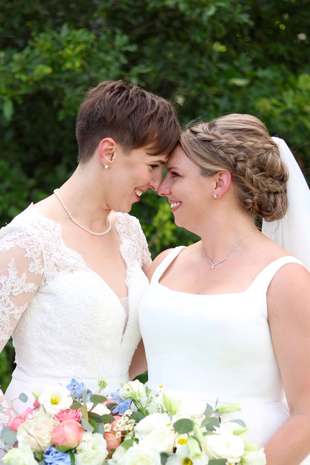 Two brides forehead to forehead looking at each other lovingly at Farms at Woodend Springs