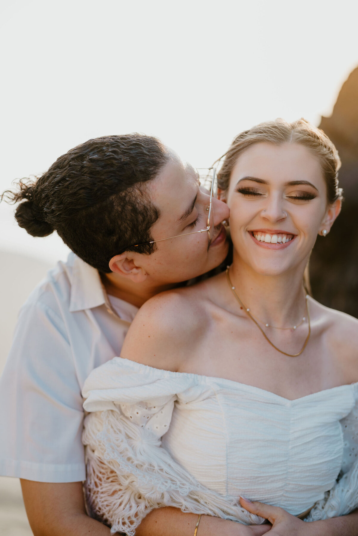 a man kissing his fiance on the cheek