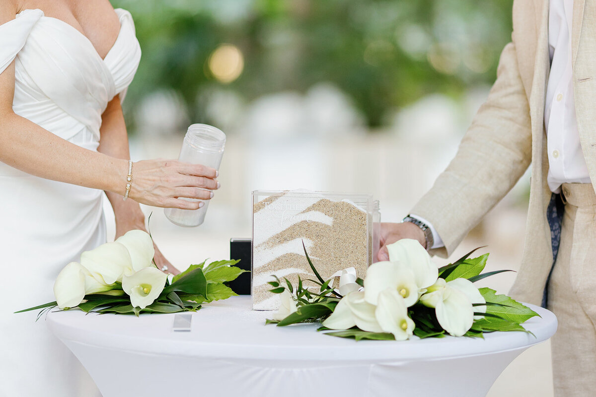 A symbolic sand ceremony representing Monica and Austyn’s union, with elegant white florals decorating the table.