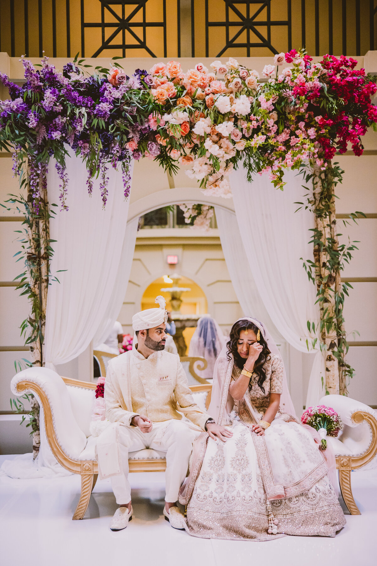 A bengali bride wipes a tear during her muslim nikkah wedding ceremony with her pakistani groom while sitting on stage at the bellevue hotel philadelphia