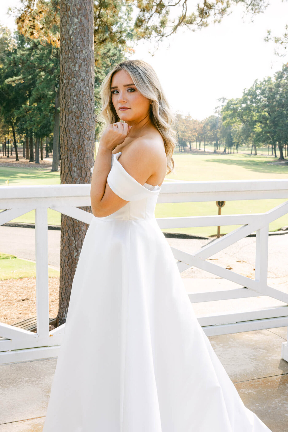 A wedding day photo of the bride in her white wedding dress posing for a portrait