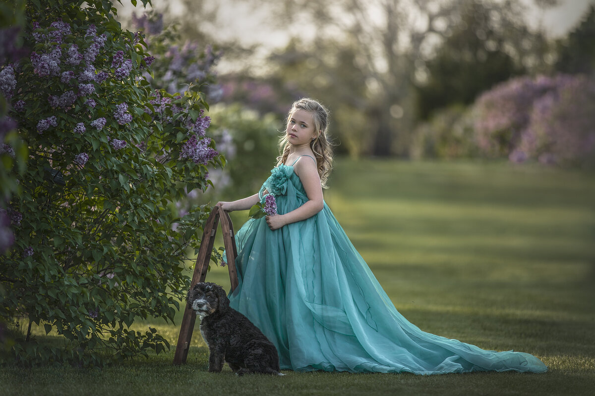 young girl in her puppy during her photography session In Ottawa Ontario outdoors in the lilacs