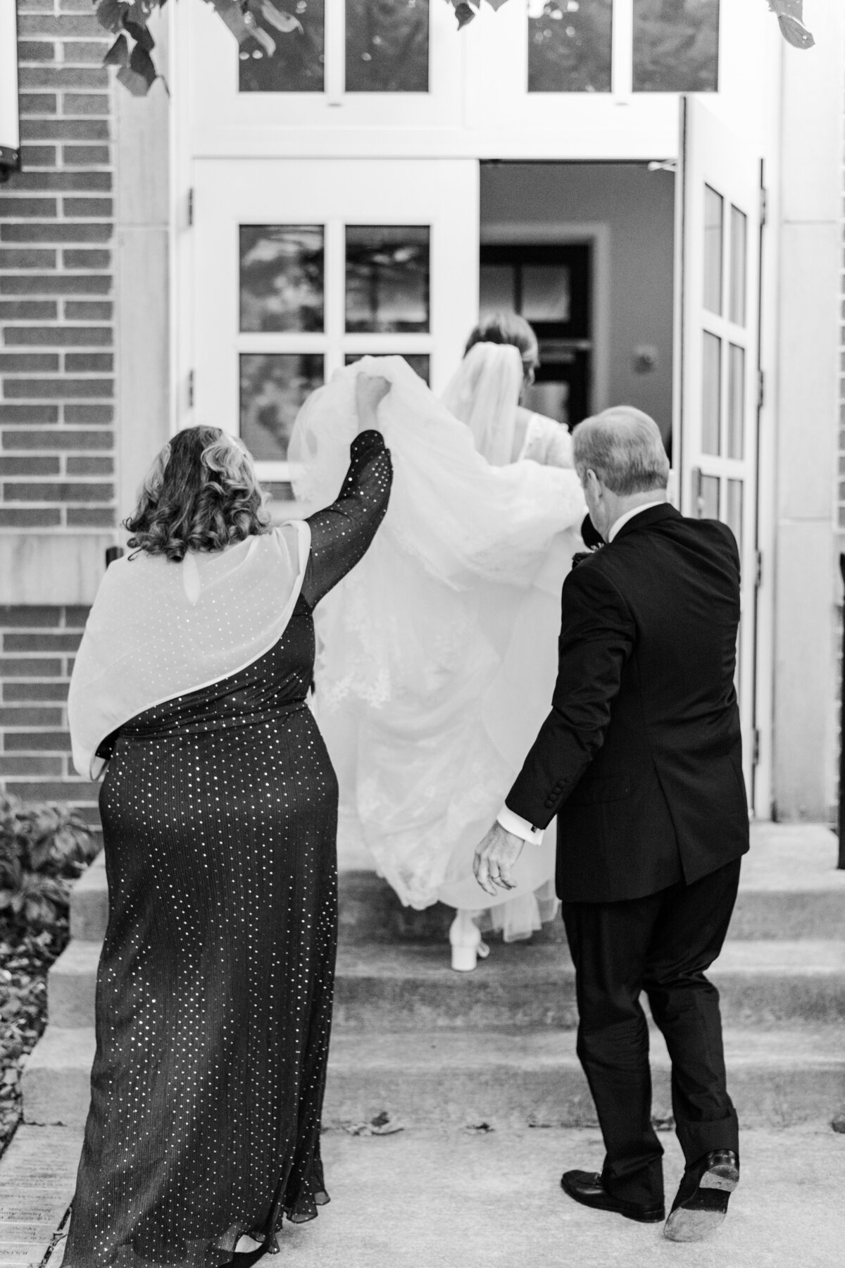 Parents help their daughter with her wedding dress