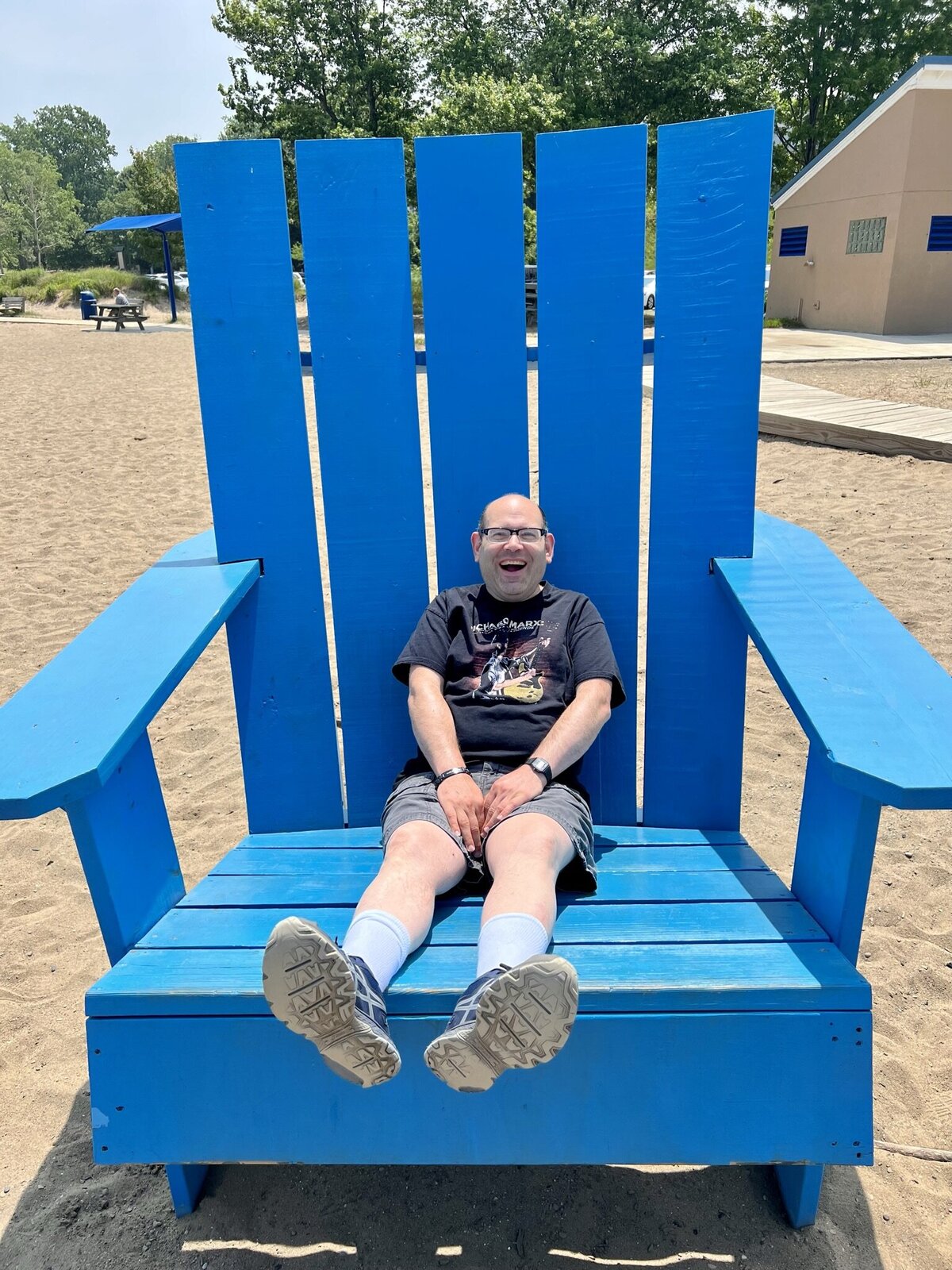 Image of solid rock friend sitting on giant chair at beach.