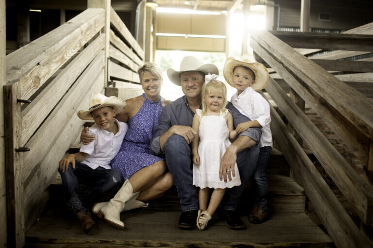 A family having fun with creative props and playful poses, making their photoshoot one to remember a the stockyards in fort worth