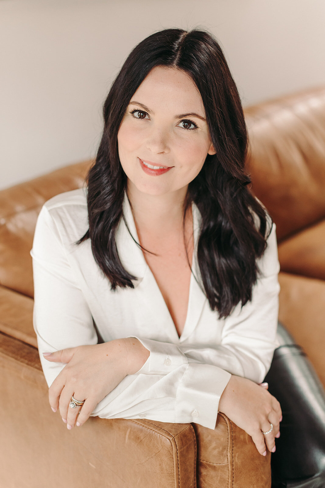 Utah Family Photographer captures woman sitting on bran leather sofa