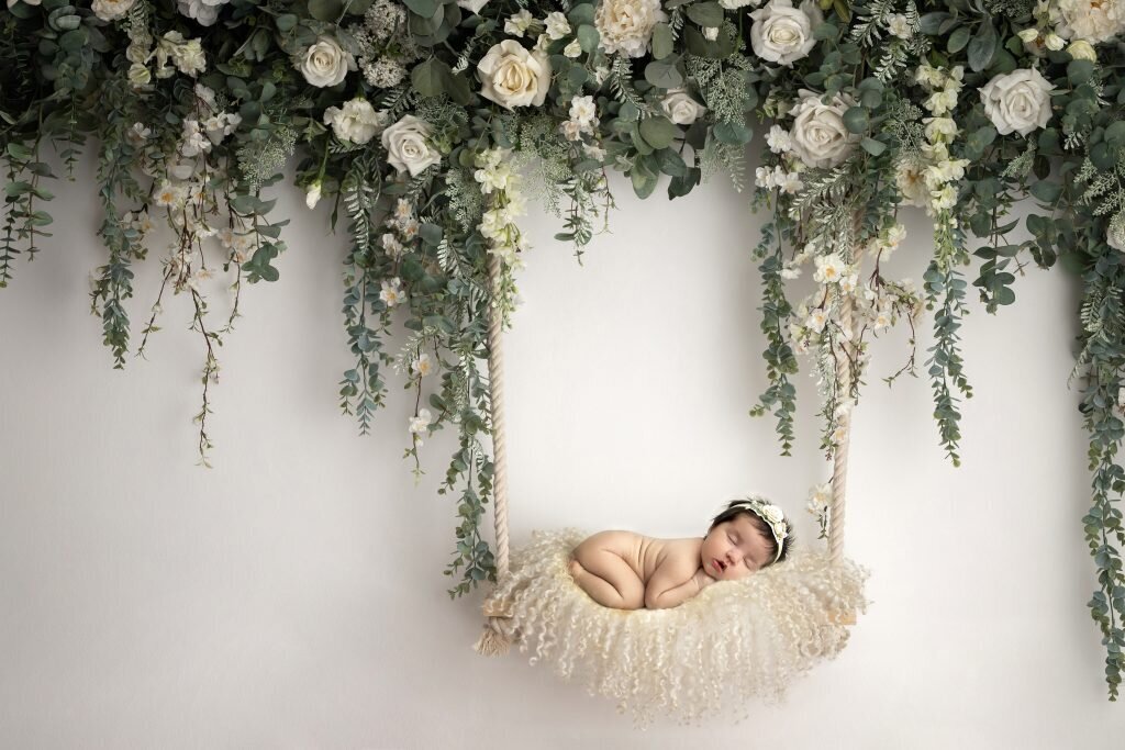 sleepy baby in a swing with floral background