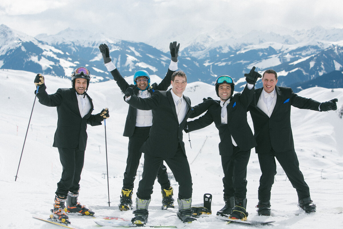 Groom walking through snow with wedding guests in Kitzbühel – stylish winter wedding adventure by Studio Rose