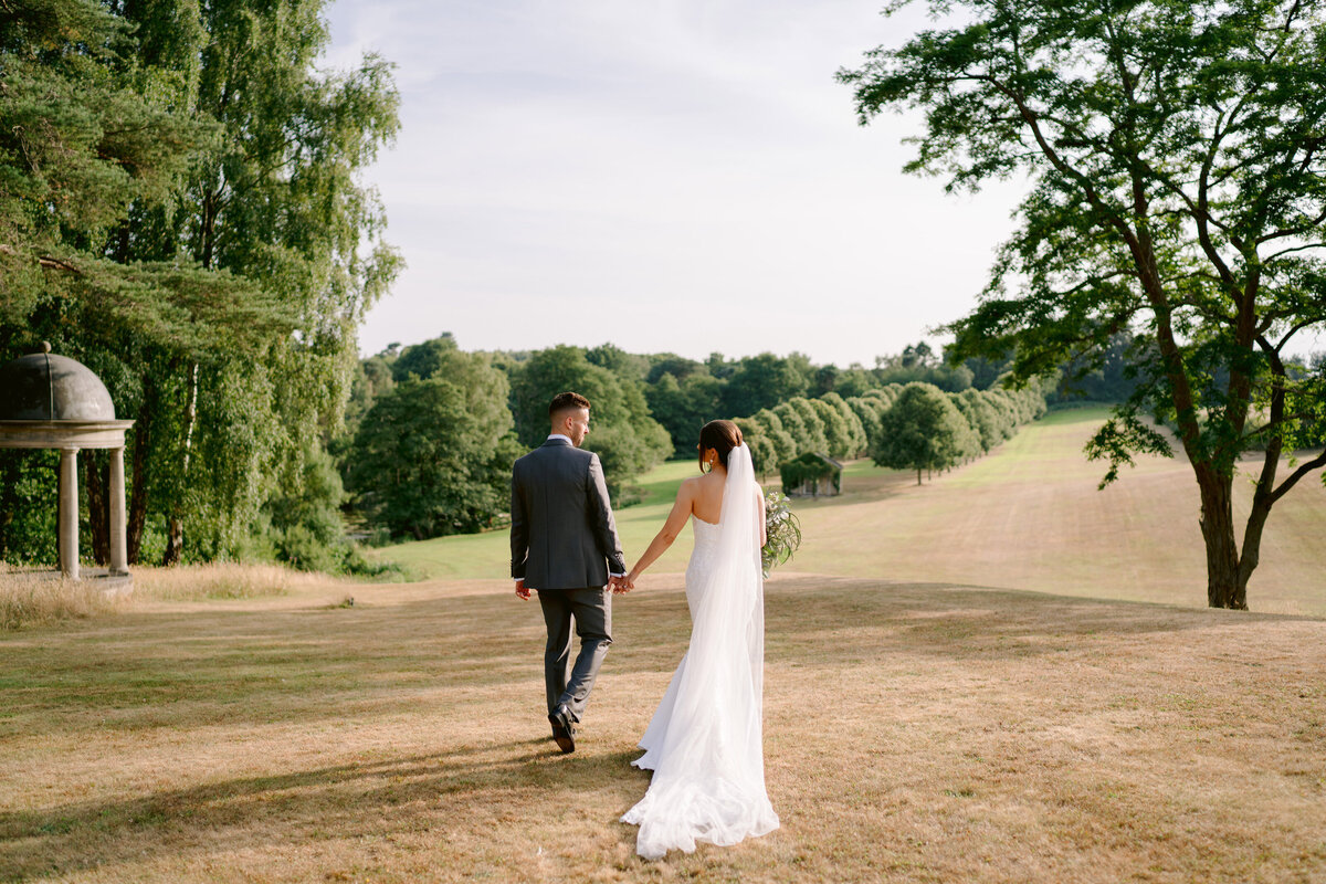 bride and groom walking through the grounds at a delamere manor wedding