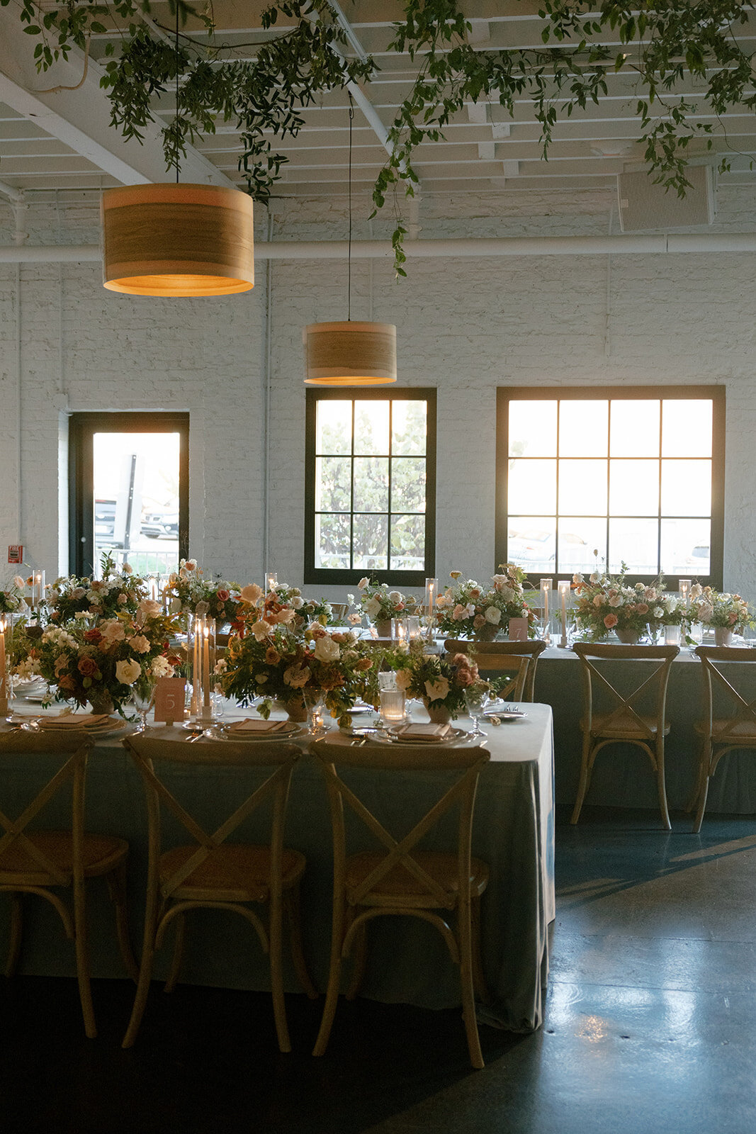 Fall wedding in Raleigh, NC highlights the beautiful autumnal setting in the Carolinas. Floral colors of copper, terra cotta, dusty pink, mauve, dusty blue, taupe, cream, and natural green. Flowers consisting of roses, dahlias, ranunculus, thistle, rain tree pods, and fall branches. Design by Rosemary and Finch Floral Design based in Nashville, TN.