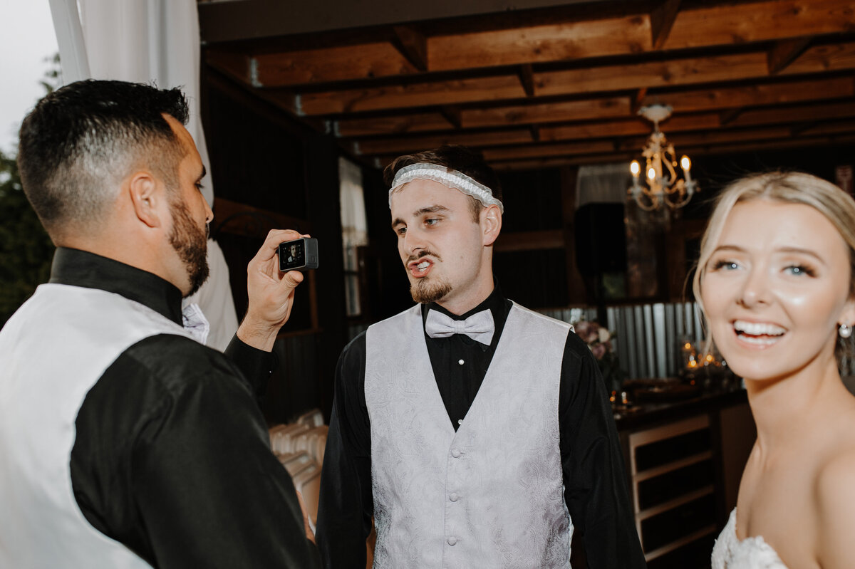 Groom wearing garter on his head and bride lauging