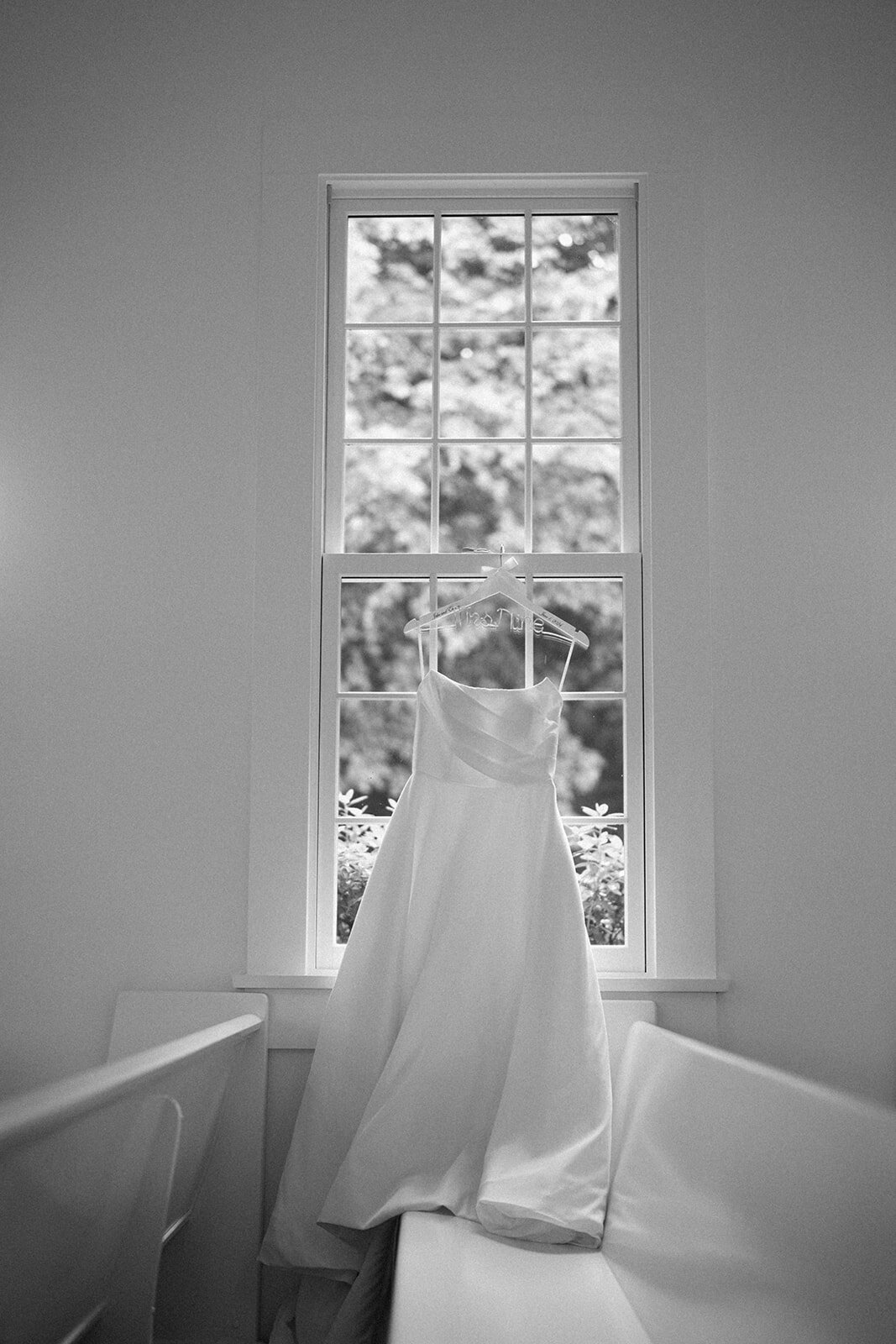 Bridal gown hanging elegantly inside The Morris Estate chapel, captured during wedding morning detail photos.