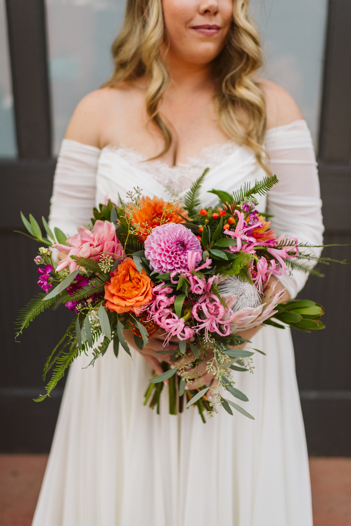 Bride holding brightly colored florals at wedding at the  St Vrain wedding venue