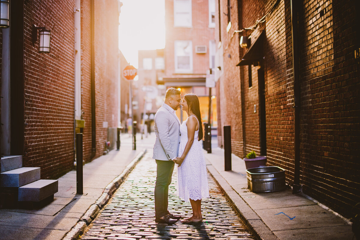 A couple sharing a moment on a cobblestone street in old city philadelphia during their engagement session
