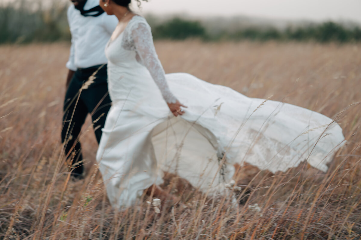 Bride and groom walk hand in hand at The Acreage in Palmyra, NE. Photo by Anna Brace, who specializes in Lincoln Nebraska Wedding Photography.