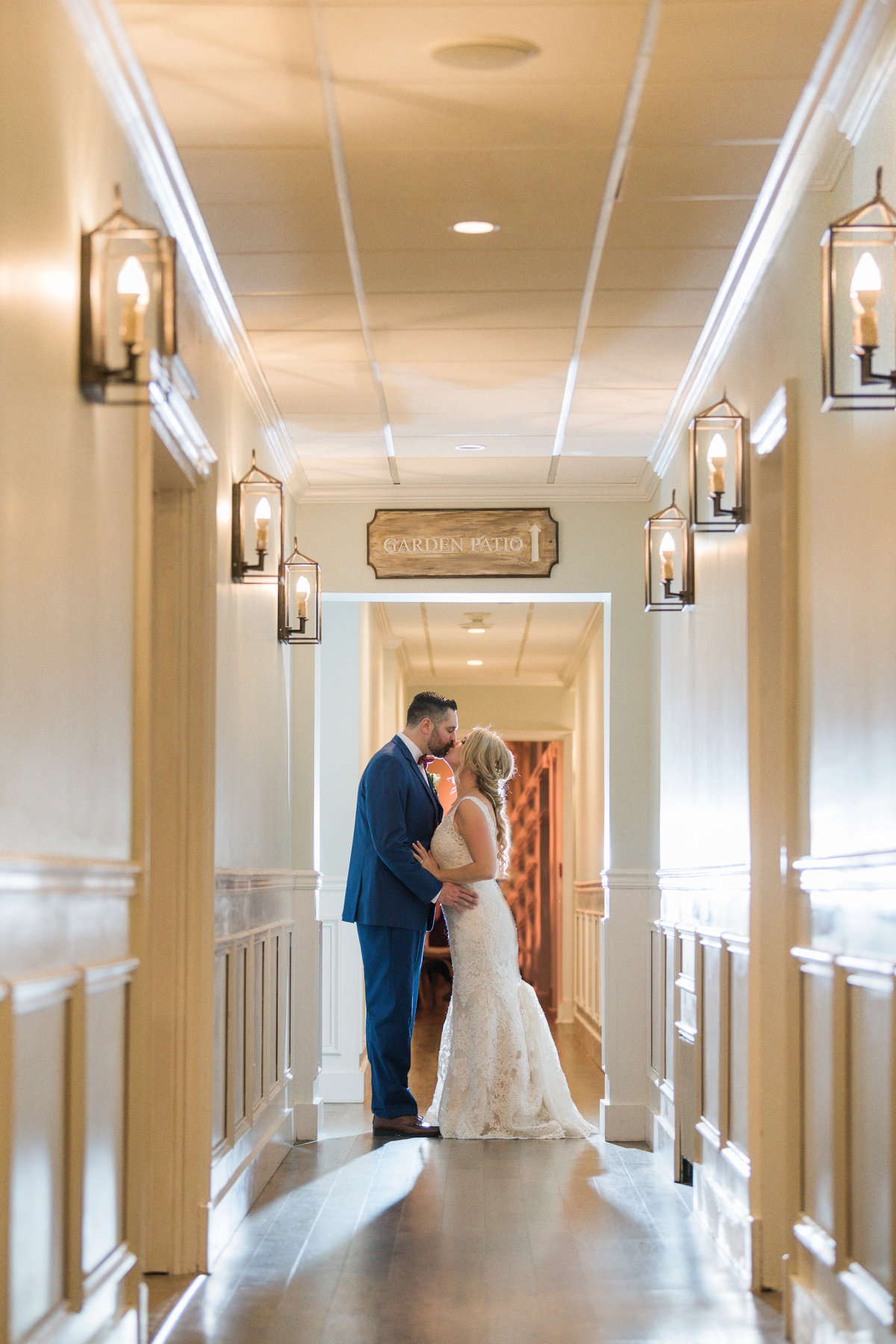 bride and groom kissing in the hallway from wedding photo at The Vineyards at Aquebogue