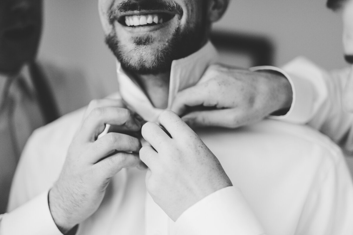 groom getting ready with the help of his groomsman