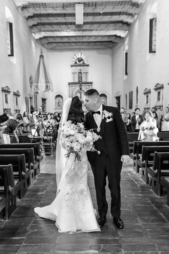 bride-and-groom-walking-down-aisle-at-mission-san-diego-de-alcala