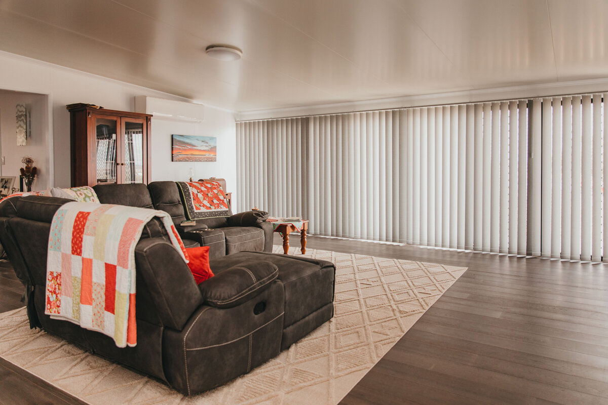 Comfortable living room showcasing vertical blinds for light control.