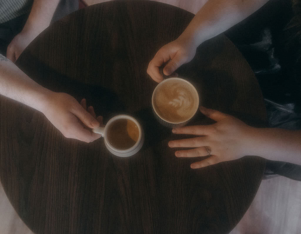 Two people with coffee sitting at a table.