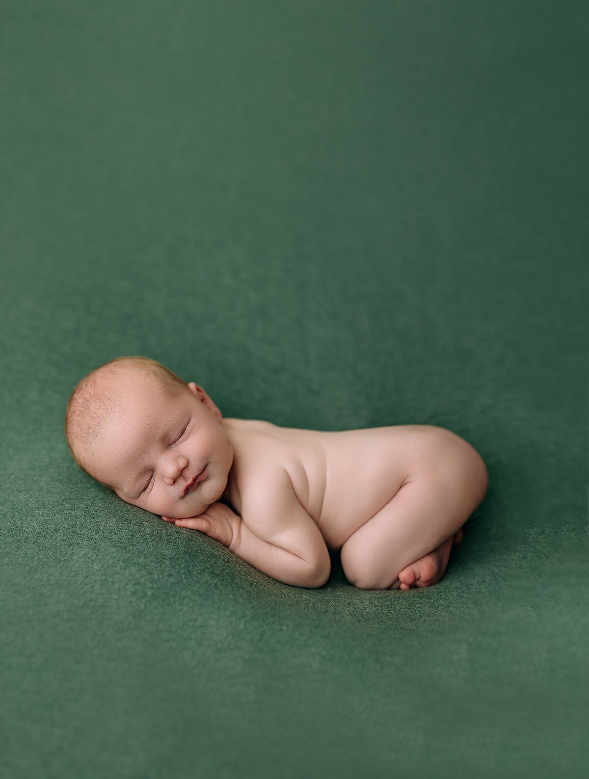 newborn boy on green at photography studio in Harrisonburg, VA