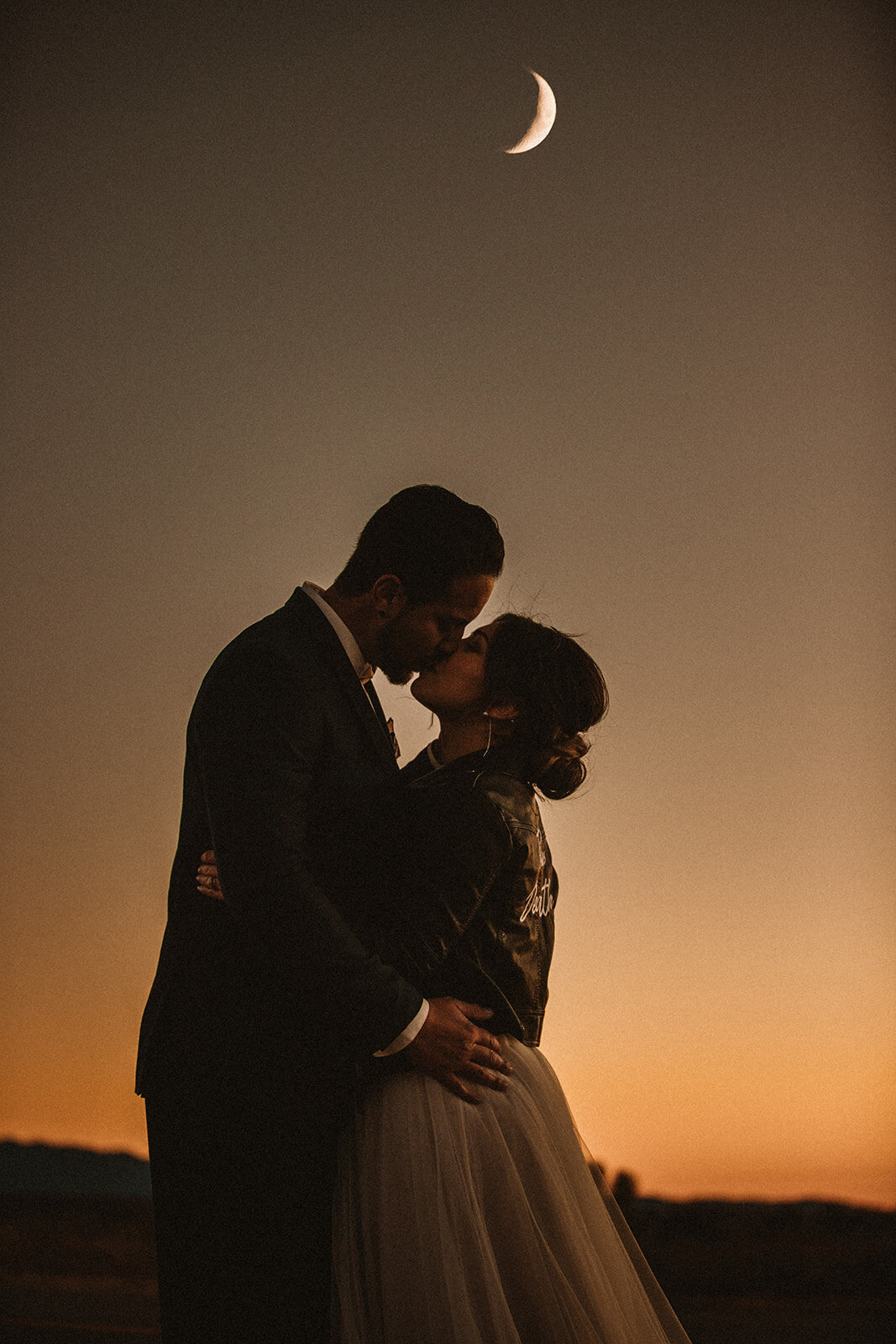 couple kisses under a crescent moon in new mexico