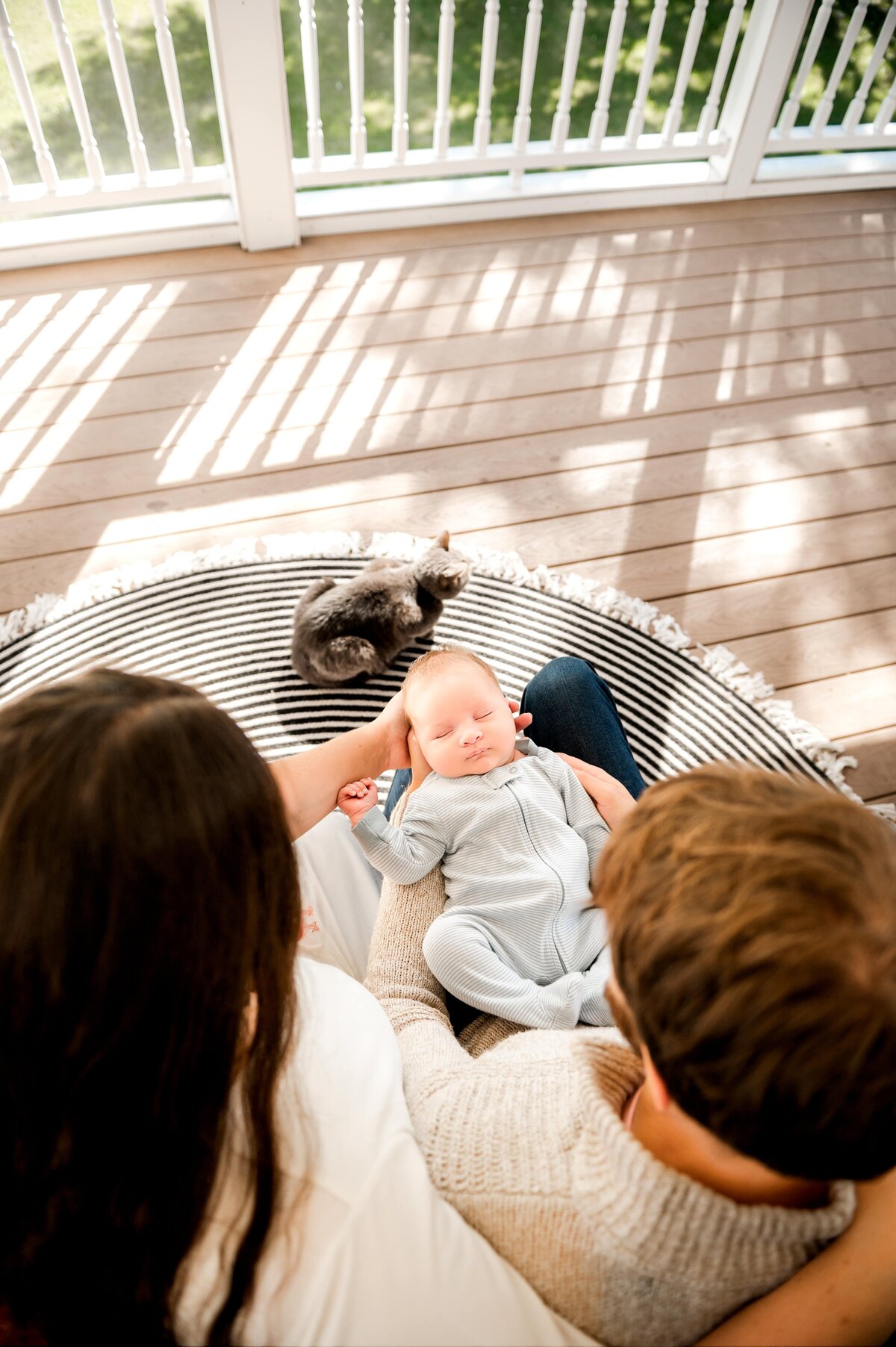 parents outside in Baltimore, Md home holding a newborn baby boy