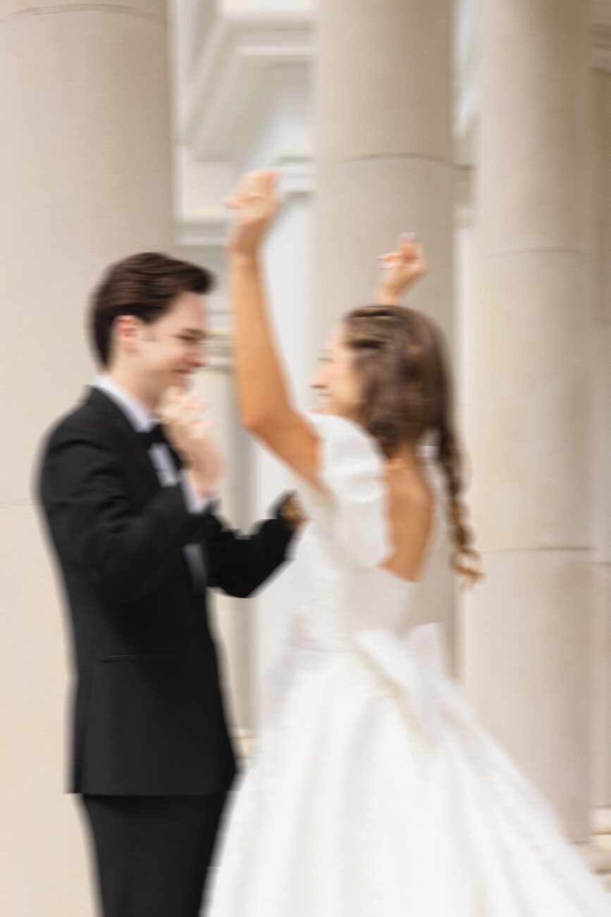 bride and groom celebratory dance in front of columns