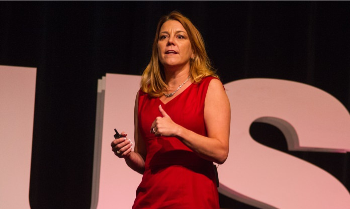 Motivational speaker, Karin Hurt, presents on stage at an event