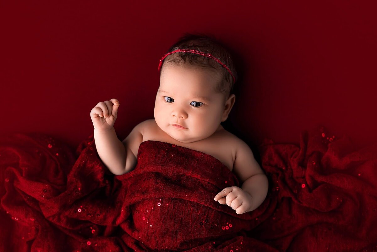 mobile-in-home-newborn-photography-vancouver-fraser-valley_baby-girl-eyes-open-red-blanket