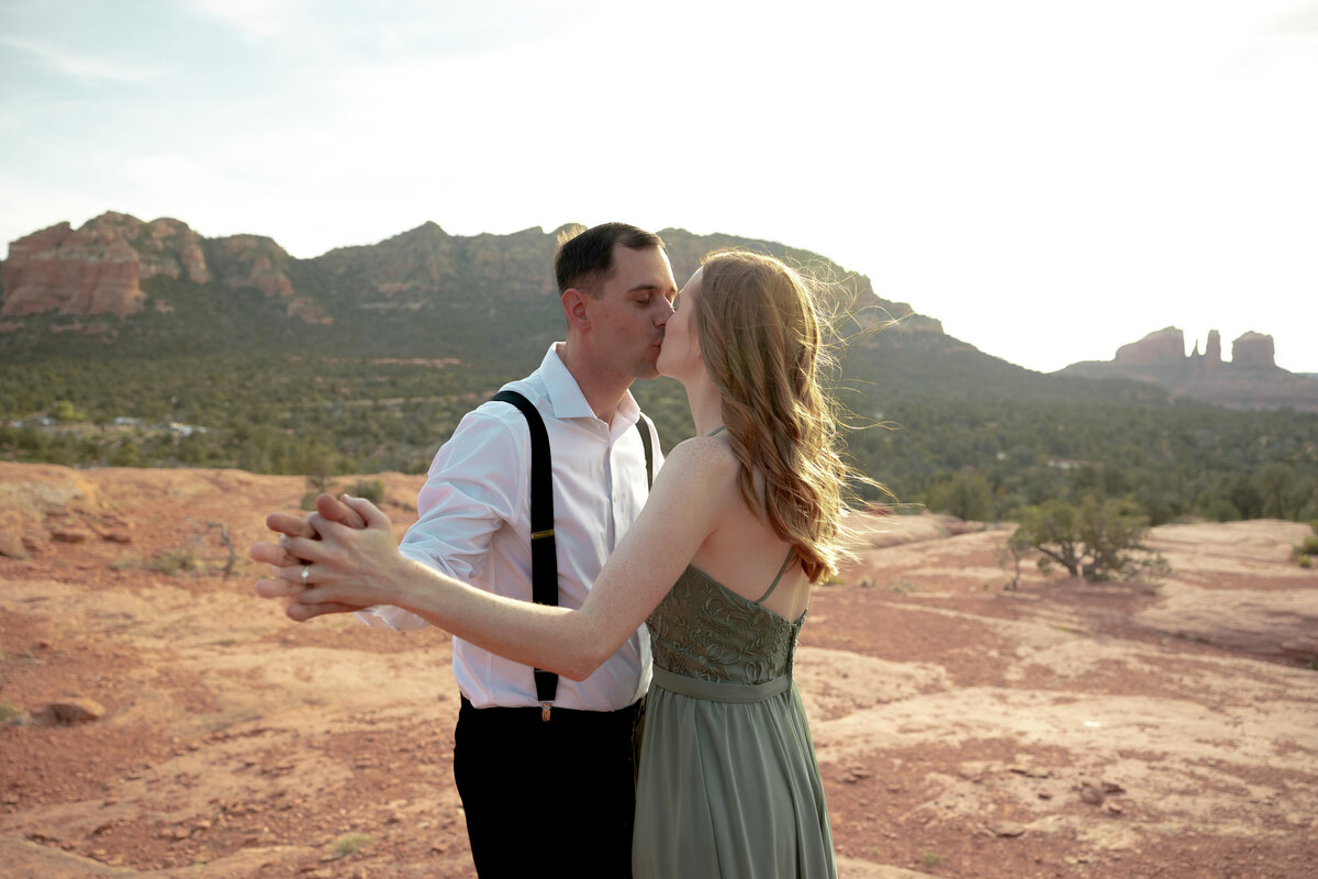 Couple standing against red rock backdrop during Sedona engagement session