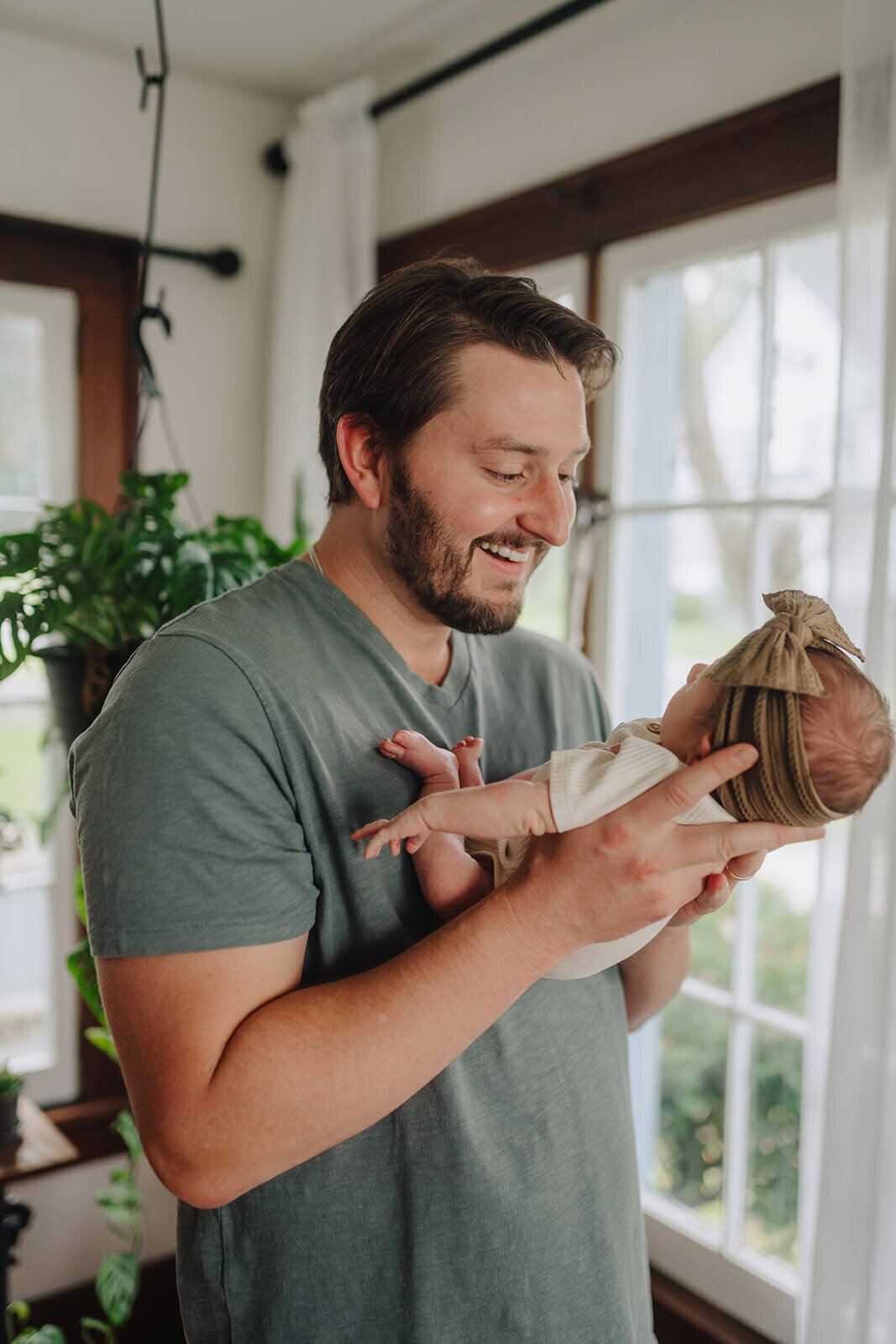 Man holding baby at newborn photoshoot at Finger Lakes, NY