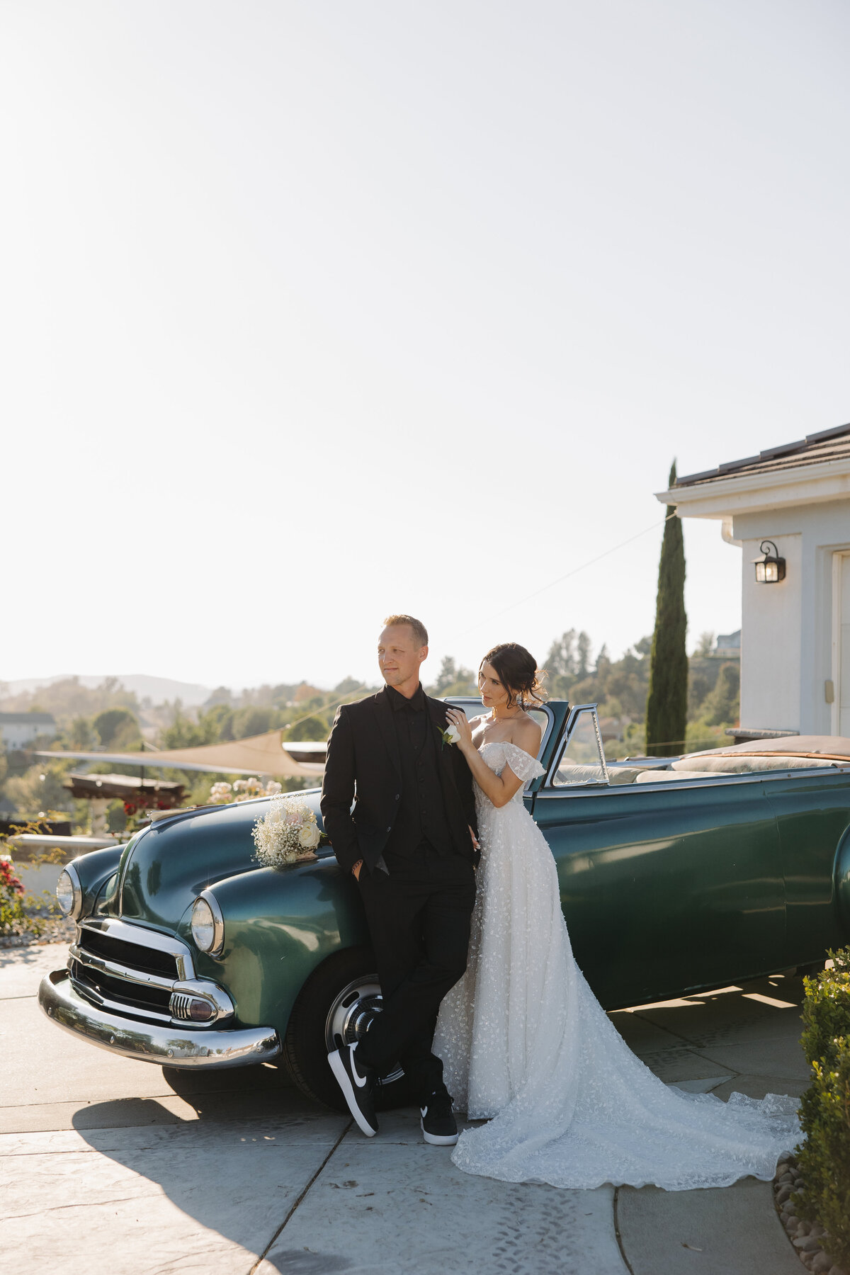 bride and groom next to vintage car