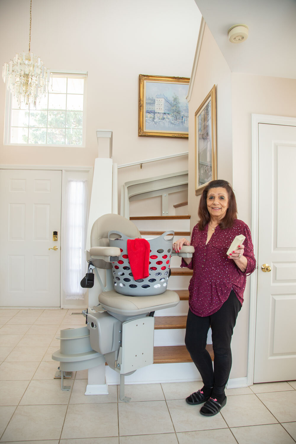 A woman standing next to a laundry basket on a chair