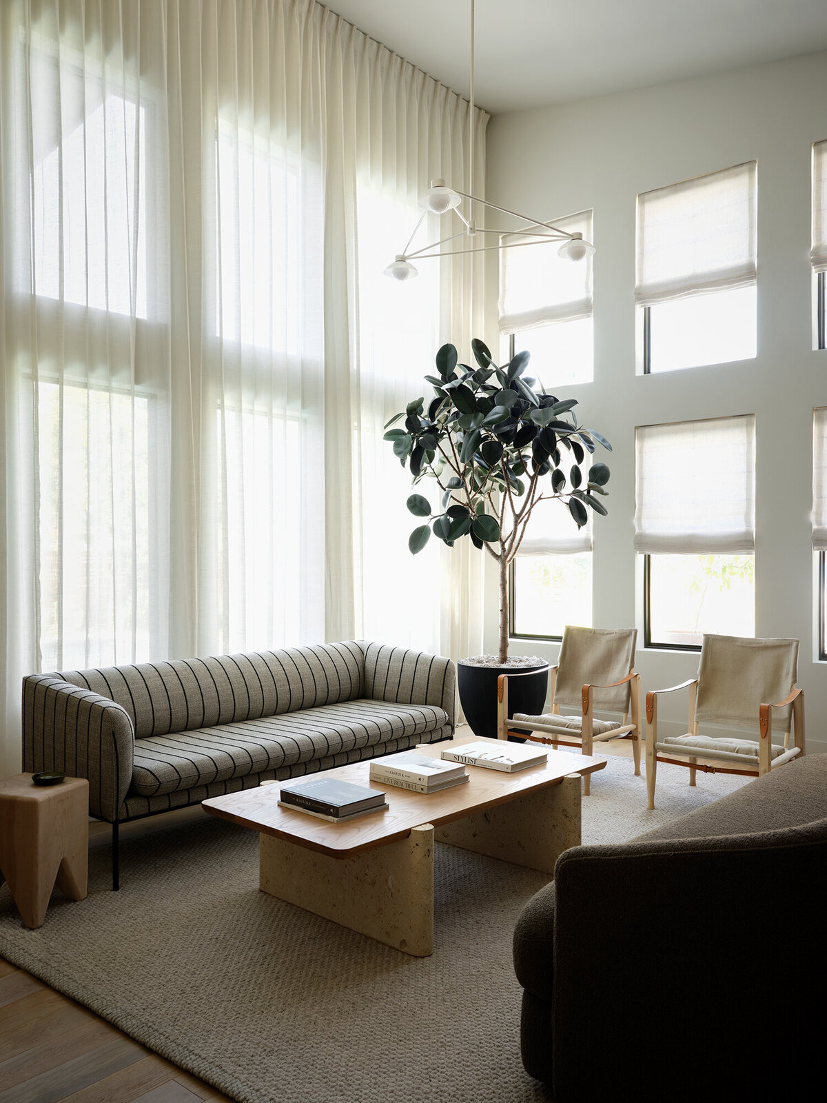 timeless-living-room-modern-stripe-sofa-linen-curtains-allied-maker-yucca-stuff-travertine-coffee-table-oak-safari-chairs-scandinavian-interior-design-austin-home-house-franc