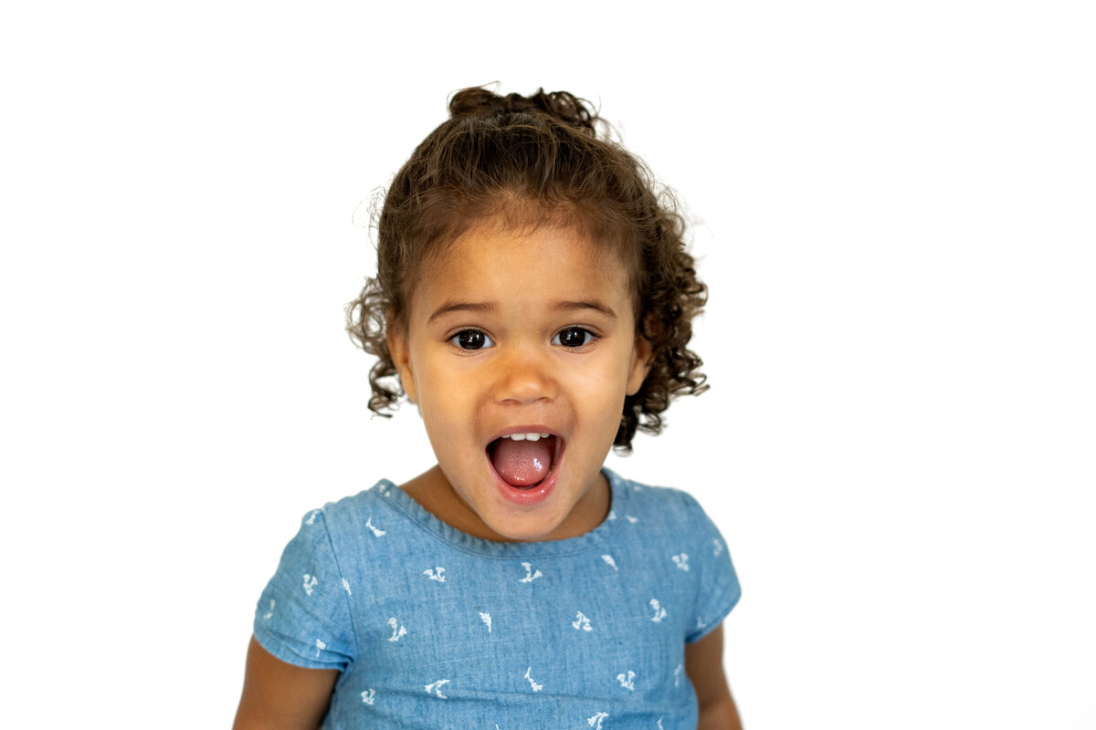 Little girl in blue dress smiling for school photo