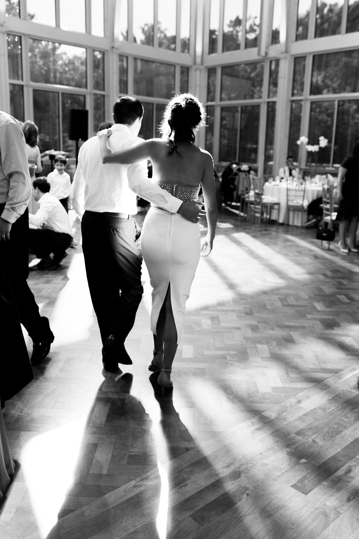 Couple holds each other while walking onto the dance floor at their birthday party.