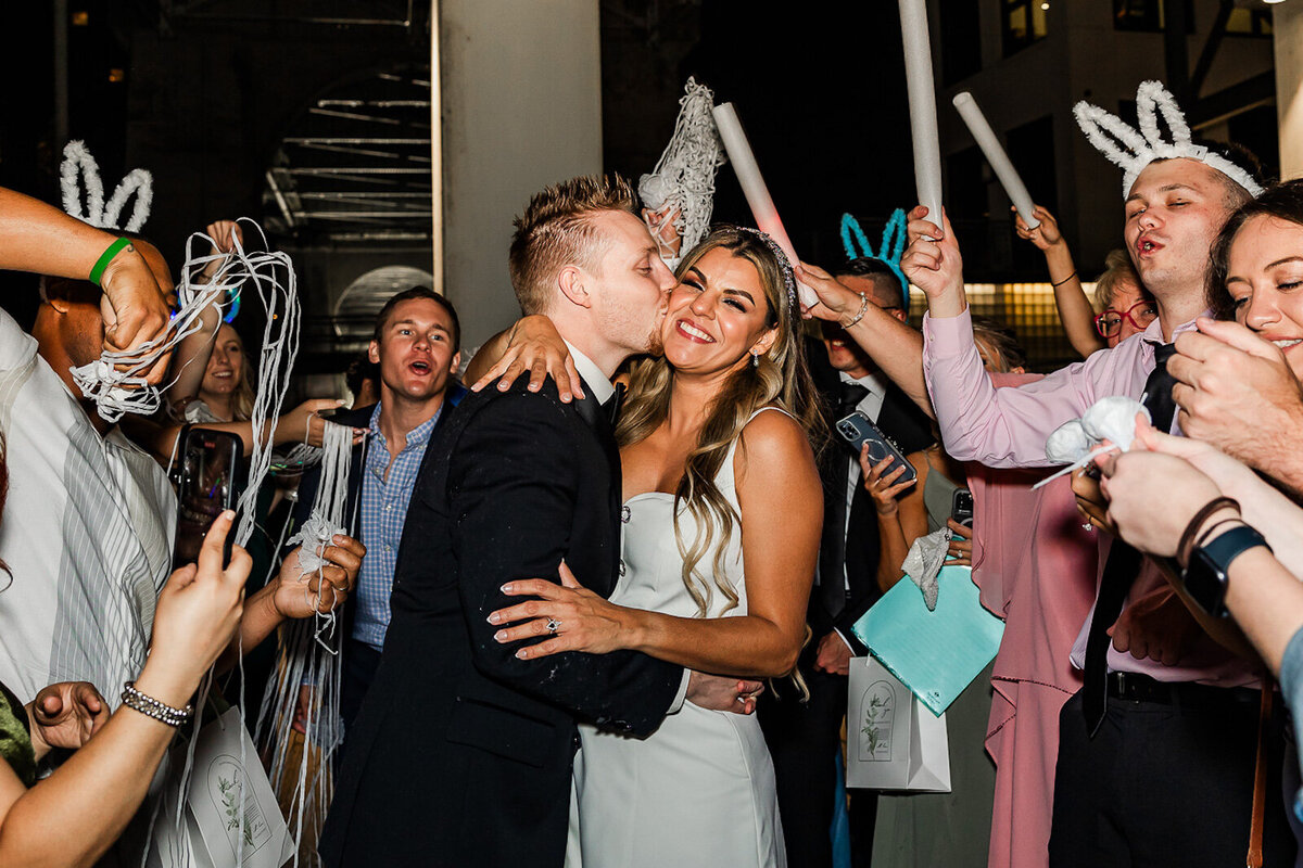 Bride and groom embracing as guests cheer