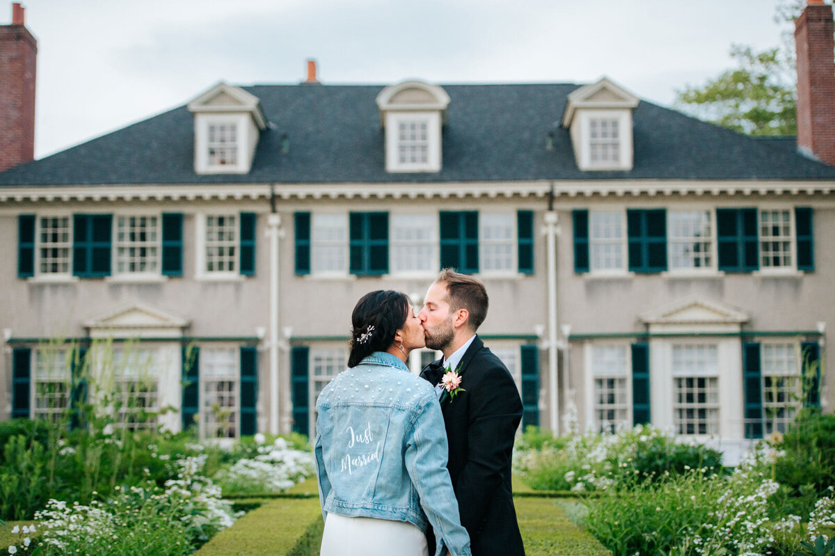 bride and groom kissing in garden at hildene with just married jean denim jacket